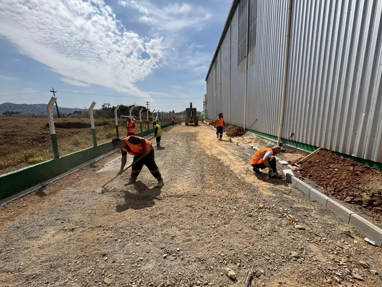Equipe da Estater regularizando a base de brita e assentando o meio-fio em área industrial