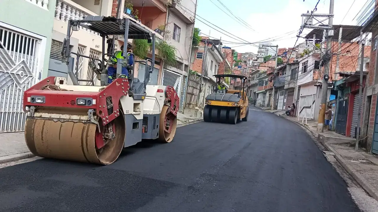 Recapeamento asfáltico em rua residencial na Grande São Paulo, com rolo compactador